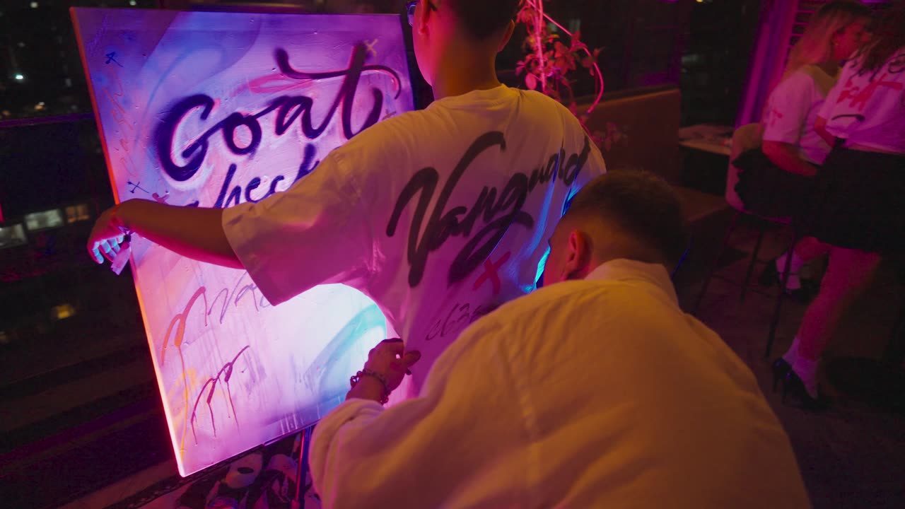 Artista pintando un lienzo con luz neón en la activación de Vanguard